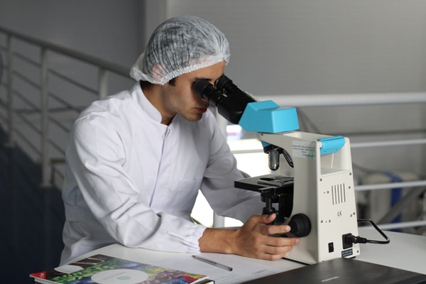 man checking in microscope inside laboratory