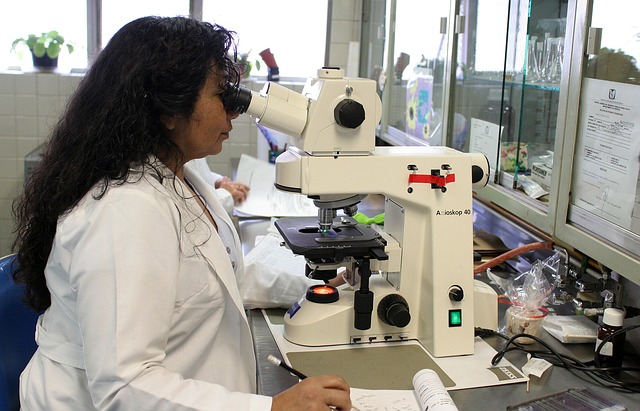 Woman physicist using a microscope